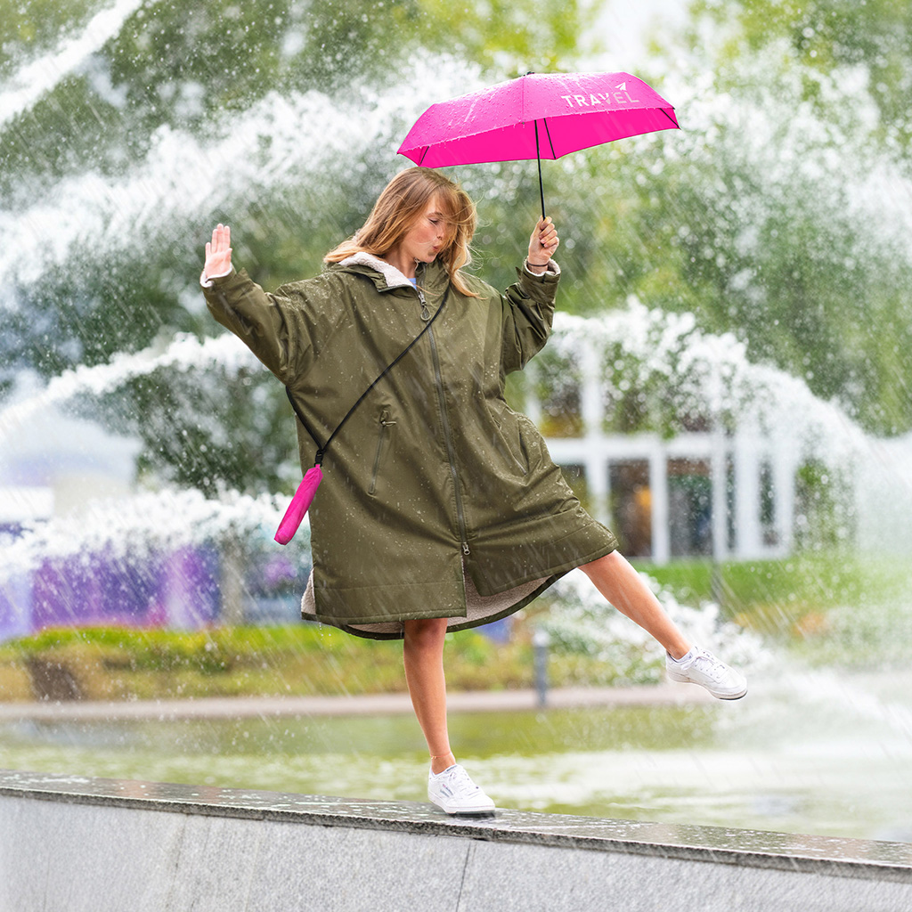 Frau mit Taschenschirm FiligRain to Go tanzt am Springbrunnen