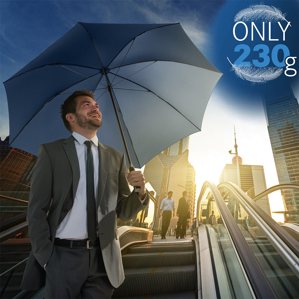 Mann mit Gästeschirm FARE® Carbon UltraLight auf Rolltreppe