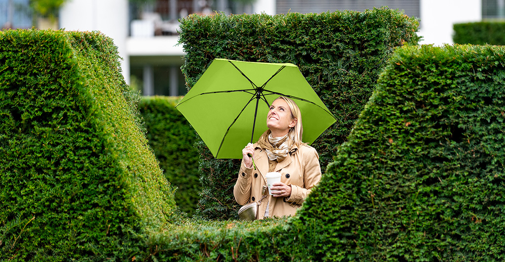 FARE Ökobrella in der Hand einer blonden Frau in der Natur
