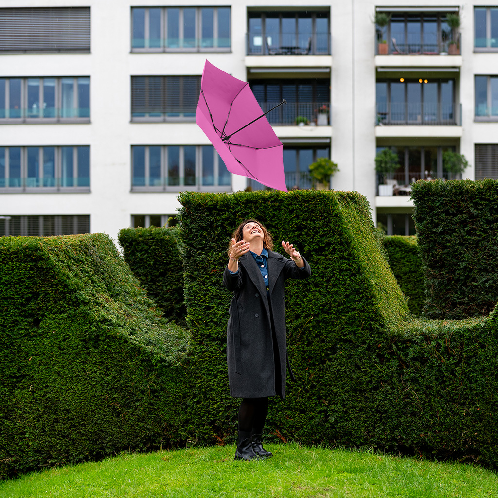 Frau wirft schirm in die Luft
