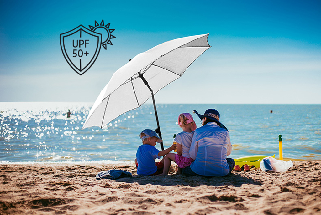 Familie am Strand unter Sonnenschirm