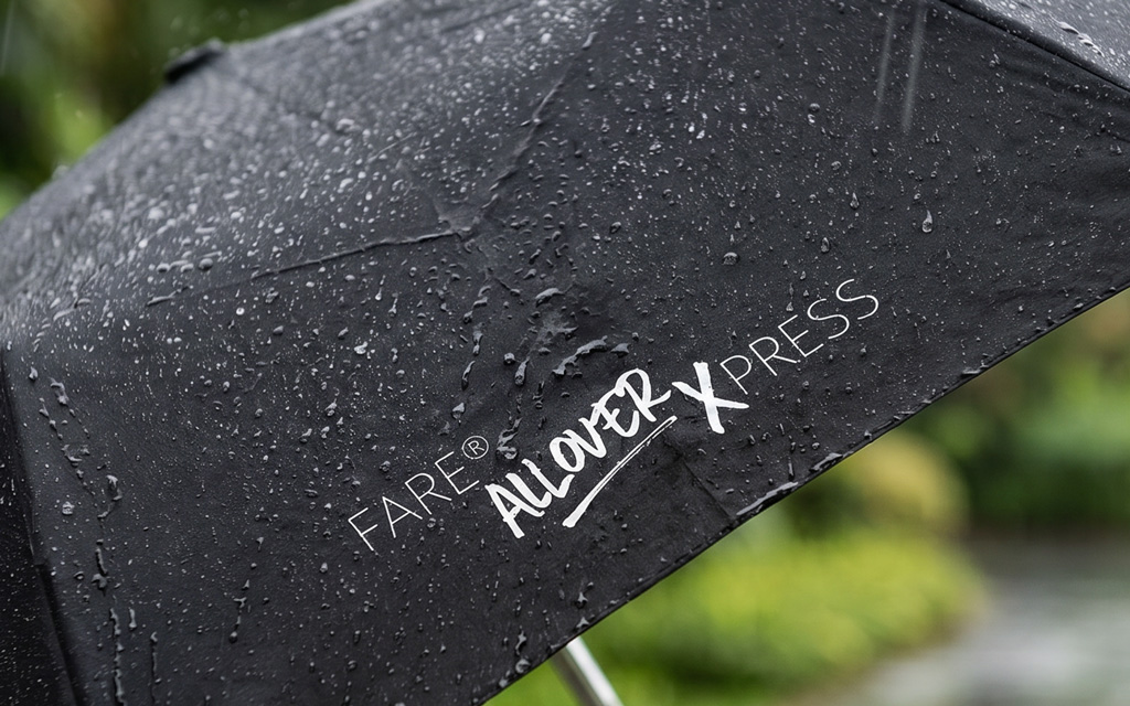 Close-up of a wet black panel featuring a white print reading ‘FARE Allover Xpress’